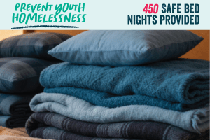 Blankets and pillows pilled up with the words Prevent Youth Homelessness and 450 Safe Bed Nights Provided above.
